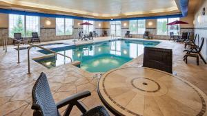 罗斯切尔德Best Western Plus Wausau-Rothschild Hotel的一个带桌椅的酒店客房的游泳池