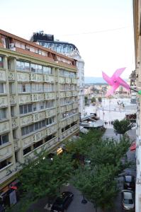 斯科普里Ars Square Apartments的一架粉红色的大飞机飞越了一座建筑物