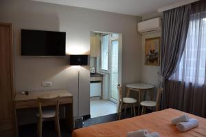 斯科普里Ars Square Apartments的酒店客房配有一张床、一张书桌和一间厨房。
