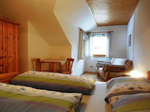 马里亚霍夫斯贝尔自然公园农家乐的一间卧室配有两张床、一张桌子和一张沙发