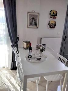 萨米Themis Apartments的白色餐桌,配有葡萄酒瓶和玻璃杯