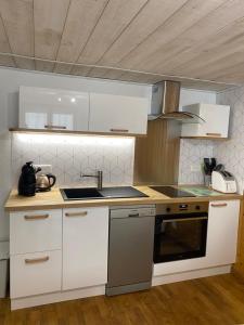 安格勒Cathy的厨房配有白色橱柜和炉灶烤箱。