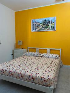 梅利萨诺Casa Gessica的一间卧室设有一张床和黄色的墙壁