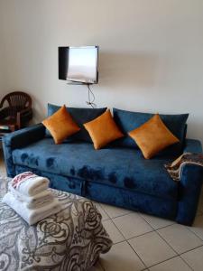 卡博尼格洛Studio avec piscine Cabo Dream à Cabo négro的一张带枕头的蓝色沙发以及墙上的电视