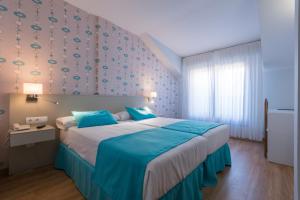 擞莫贝蒙海滩酒店的一间卧室配有一张带蓝色床单的大床