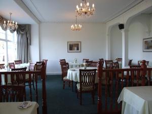 罗撒西维多利亚酒店的用餐室配有桌椅和吊灯。