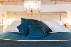 阿尔贝罗贝洛Palazzo Scotto的一张带蓝色和白色枕头的床