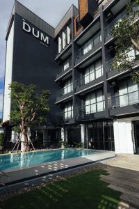 清迈DUM Hotel - Si Phum的一座建筑前面设有游泳池