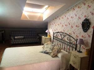 马尔帕尔蒂达德卡塞雷斯Hostal La Caballeriza的卧室配有白色的床铺,墙上挂着鲜花