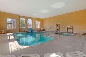 佩森佩森康福特因酒店的大型游泳池,位于带椅子的大房间