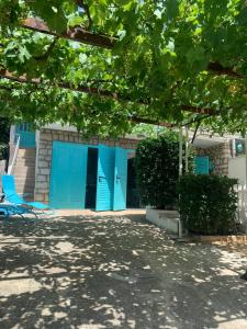 斯塔利格拉德-帕克利尼卡Petite house的蓝色的建筑,设有蓝色的门和椅子