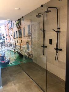 法尔肯斯瓦德Boutique Hotel de Valk的一间带淋浴的浴室,享有运河美景