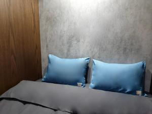 迪拜sleep 'n fly Sleep Lounge & Showers, D-Gates Terminal 1 - TRANSIT ONLY的床上有2个蓝色枕头