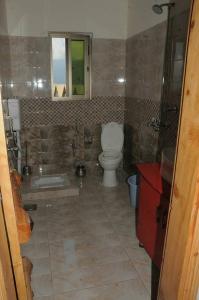 ShongranFridays Hotel的浴室配有卫生间、浴缸和水槽。