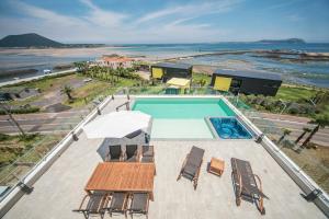 西归浦市济州阿迪朗丝酒店的一个带桌椅的游泳池和海滩