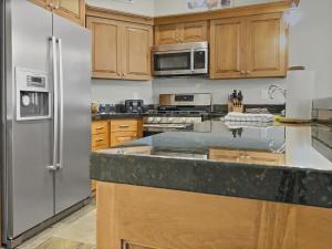 帕克城B11 Powder Run condo的厨房配有木制橱柜和不锈钢冰箱。