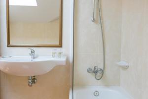 里博雷多奥卡斯特罗酒店的浴室配有盥洗盆和带镜子的淋浴