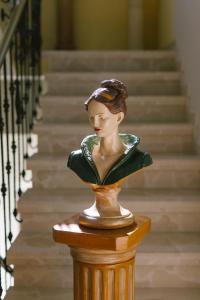 里博雷多奥卡斯特罗酒店的坐在楼梯旁桌子上的女人的雕像
