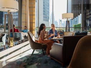 迪拜迪拜国际金融中心四季酒店的坐在大楼顶部桌子上的两名妇女