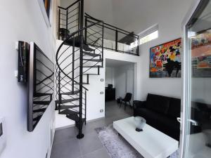 圣雷莫Palms Luxury Suites Sanremo的带沙发的客厅内的螺旋楼梯