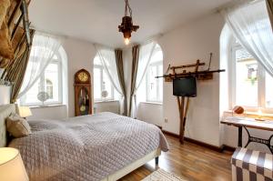 安娜贝格-布赫霍尔茨Ferienwohnung LANDHAUSSUITE Annaberg-Buchholz的卧室配有床、时钟和窗户。