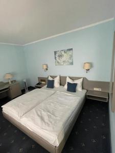 美因河畔法兰克福博格酒店的卧室配有白色大床和蓝色的墙壁