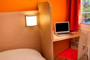 兰斯兰斯苏德高级酒店 - 博扎讷的一间卧室配有一张床和一张桌子上的笔记本电脑