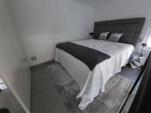 圣雷莫Palms Luxury Suites Sanremo的卧室配有一张带黑色毯子的白色床