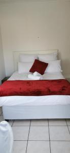 派恩敦Lytton Cresent B&B的白色的床,配有红色毯子和白色枕头