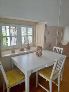 Praia do RibatejoCasa da Praia do Ribatejo - Casa da Arcada的厨房配有白色的桌子和两把椅子