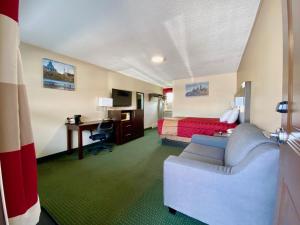 珀斯殖民地别墅汽车旅馆的酒店客房配有一张床、一张沙发和一张书桌。