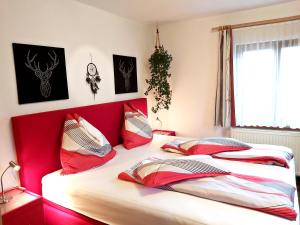 格绍Apartments Fasl的一间卧室配有两张带红色床头板的床