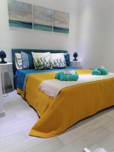 锡拉库扎La Casetta del Ronco1 Ortigia的一张大床,上面有黄色和蓝色的毯子