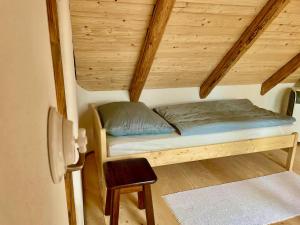 维尔克波波维采Apartmány pod Kozákem的一张小床,位于一个拥有木制天花板的房间