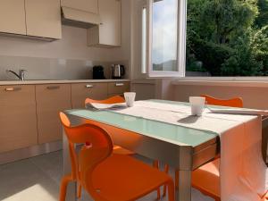 科莫Volta's Dream的厨房配有桌子和橙色椅子