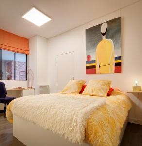 坎佩尔galerie Angle3的卧室配有一张床,墙上挂有绘画作品