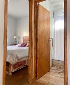 特立尼达岛Casita de Piedra 2的一间卧室设有一张床和一个大型木门