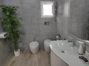 奥罗塞伊Romantico open space Luna的一间带水槽和浴缸的浴室以及两株植物