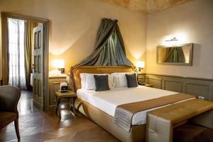 福萨诺帕拉佐莱希尼酒店的一间卧室配有一张带天蓬的大床