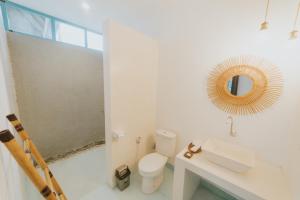 龙目岛库塔Birru Inn的白色的浴室设有卫生间和镜子