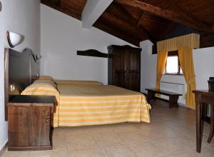 CalvelloHotel Pietrapanna的一间卧室配有一张黄色和棕色毯子的床