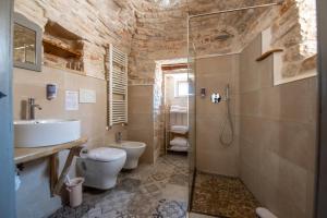 阿尔贝罗贝洛Trulli Holiday Deluxe & Wellness的一间带水槽、卫生间和淋浴的浴室