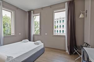 特雷维索MyPlace Treviso Vittoria的一间卧室设有一张床和两个窗户。