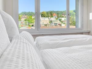楚格ARISER - Mountain View Business Apartment的一间白色卧室,配有两张床和两个窗户