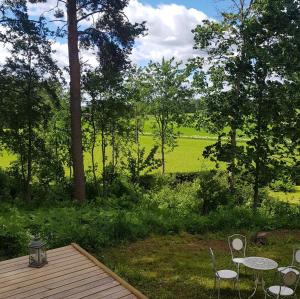 LoppiRauhaa, hyvää unta maaseudulla的庭院设有2张桌子和椅子,田野