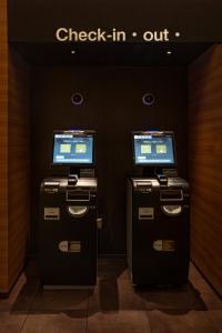 广岛Hotel Xcell 広島 流川通り的两个安密机器,位于一个有入住标志的房间
