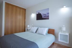 萨格里什sagres apartment best location beach and town life的一间卧室配有一张床和一个木制橱柜