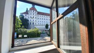 多瑙河畔诺伊堡Neuburg City Apartments的享有大楼景致的开放式窗户