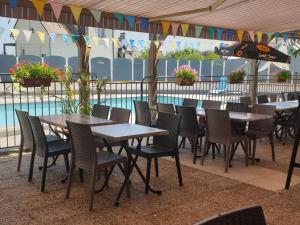 茅尔斯国际之家克吕泽尔酒店的游泳池旁的一排桌椅