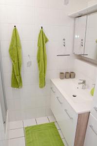 沃茨伯格Voitsberg-Apartments的白色浴室的墙壁上配有绿色毛巾